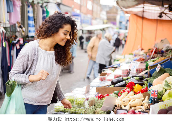 菜市场年轻女人微笑的女人手拿购物袋买菜购物